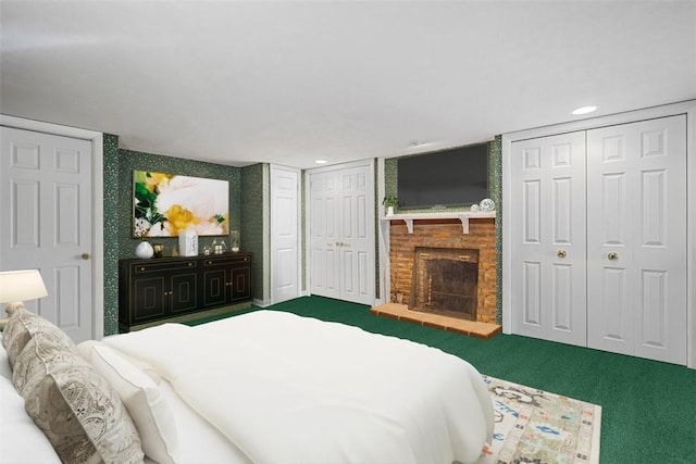 carpeted bedroom with two closets and a brick fireplace