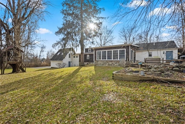 back of house featuring a sunroom and a lawn