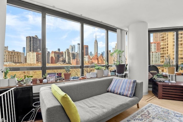 interior space with a view of city, a wall of windows, and a healthy amount of sunlight