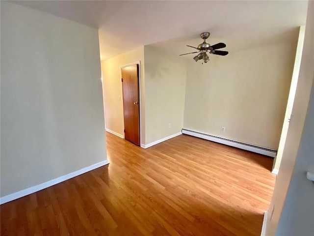 spare room with baseboard heating, ceiling fan, and light hardwood / wood-style floors