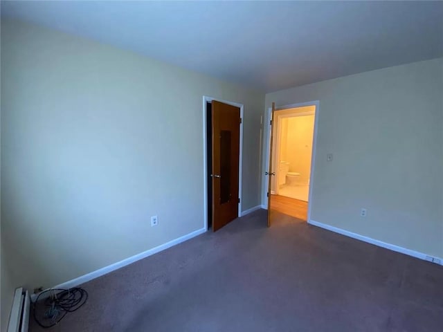 unfurnished bedroom featuring dark carpet and a baseboard radiator