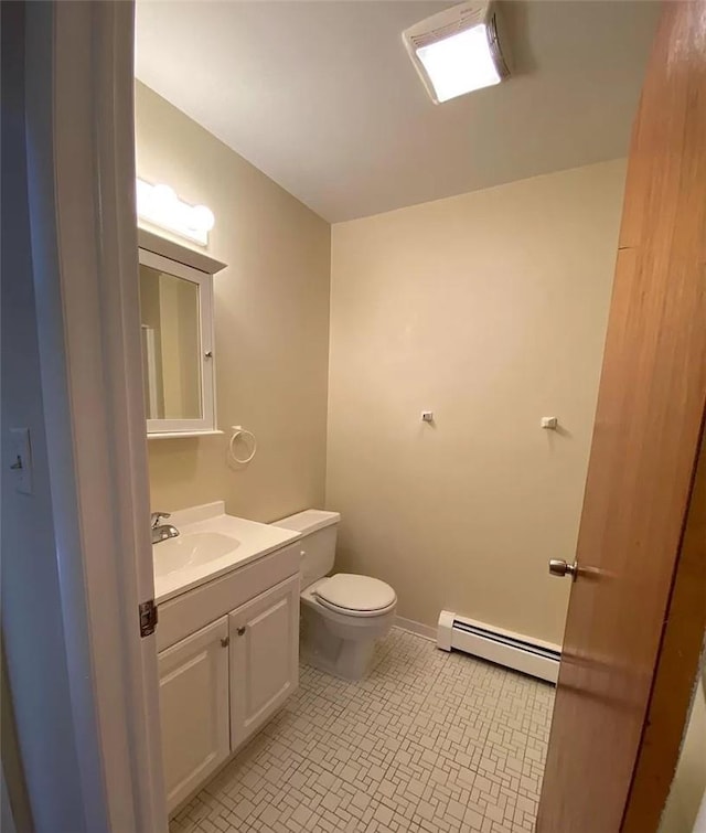 bathroom with tile patterned flooring, vanity, toilet, and a baseboard heating unit