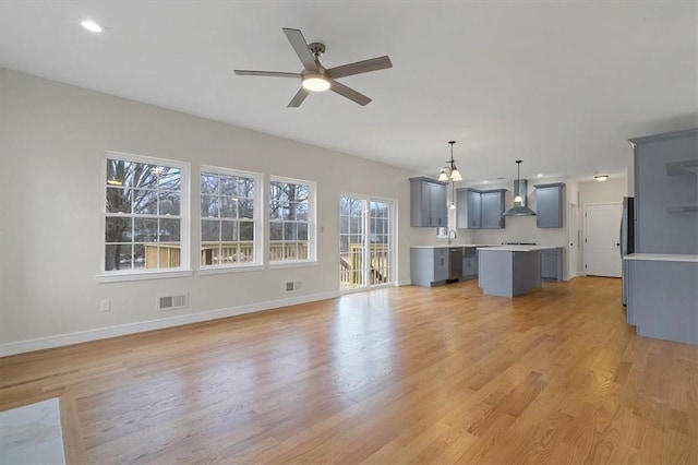 unfurnished living room with ceiling fan, light hardwood / wood-style floors, and sink