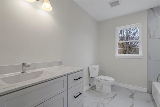 bathroom featuring vanity, toilet, and a tub to relax in