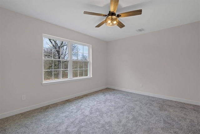 carpeted spare room featuring ceiling fan