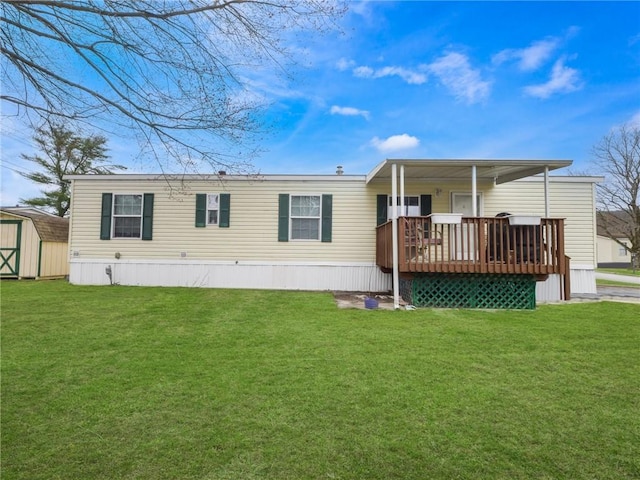 rear view of property with a lawn, a shed, and a deck