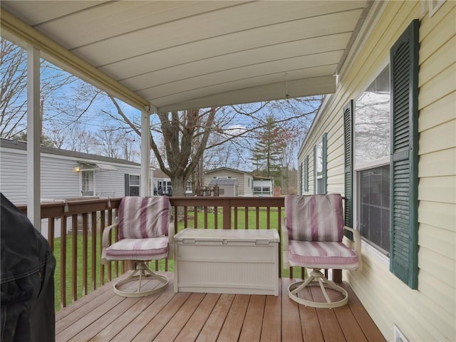 wooden terrace with a lawn and grilling area