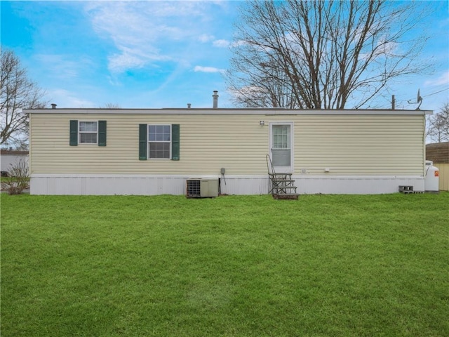 back of house featuring a yard and central AC unit