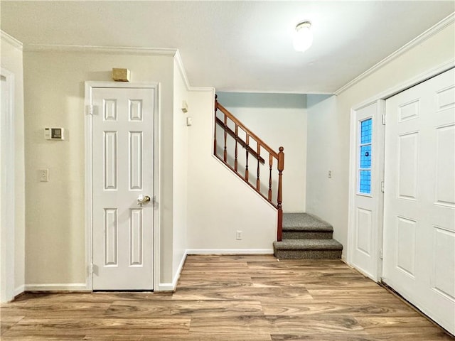 entryway with hardwood / wood-style flooring and crown molding