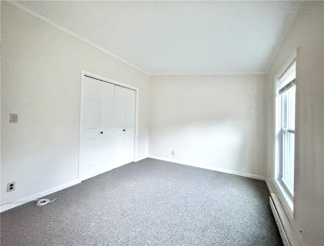 unfurnished bedroom featuring carpet flooring, baseboard heating, and a closet