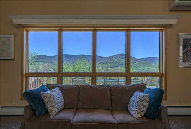 carpeted living room featuring baseboard heating, a mountain view, and a healthy amount of sunlight