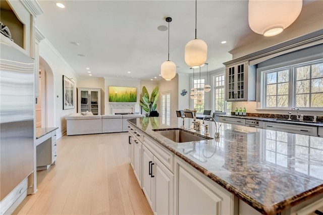 kitchen featuring white cabinetry, light hardwood / wood-style flooring, stainless steel fridge, pendant lighting, and stone countertops