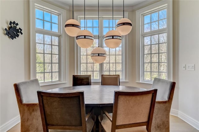 dining space with light wood-type flooring and crown molding