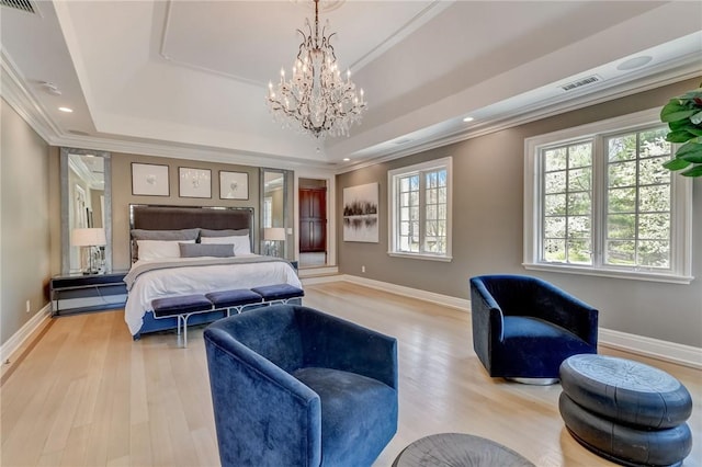 bedroom featuring a notable chandelier, a raised ceiling, light wood-type flooring, and ornamental molding