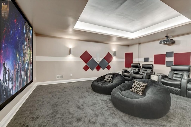 cinema room featuring carpet flooring and a raised ceiling