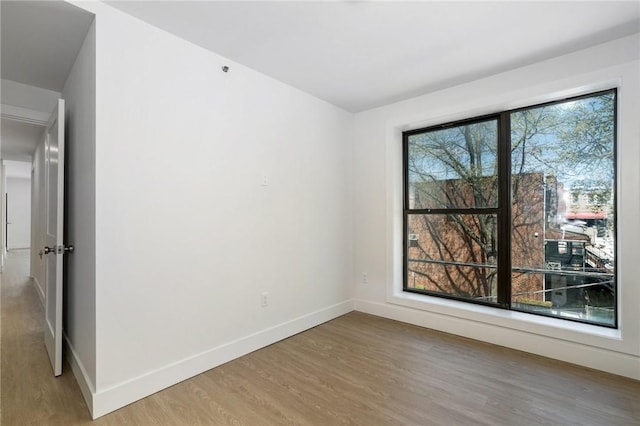 unfurnished room with plenty of natural light and wood-type flooring