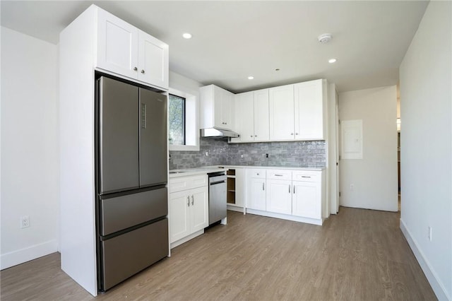 kitchen featuring white cabinets, appliances with stainless steel finishes, backsplash, and light hardwood / wood-style floors