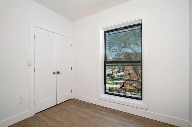 unfurnished bedroom featuring wood-type flooring and a closet