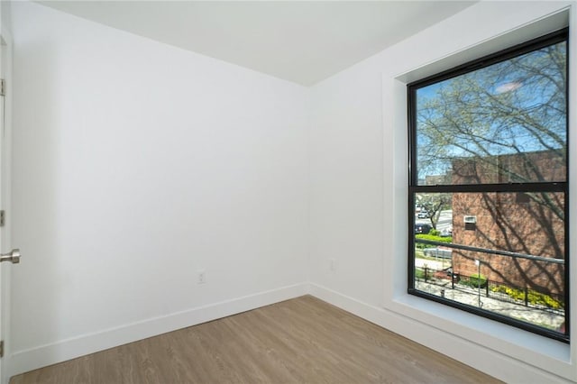 unfurnished room with wood-type flooring and plenty of natural light