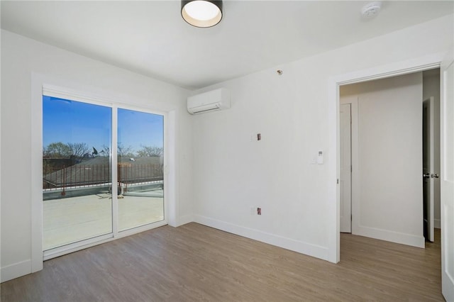 spare room with a wall mounted air conditioner and hardwood / wood-style flooring