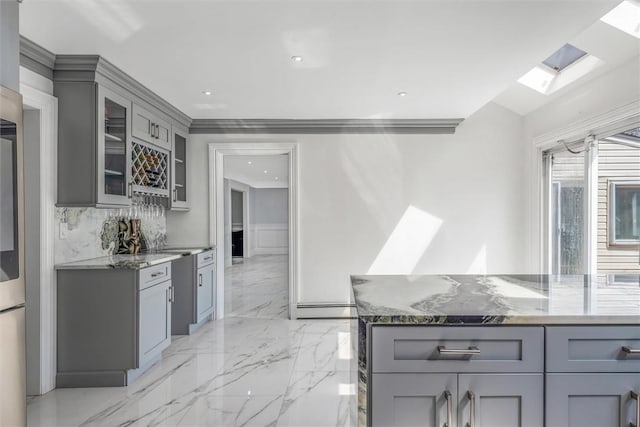 kitchen featuring baseboard heating, gray cabinets, and dark stone counters