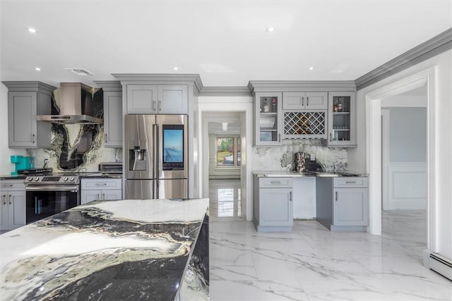 kitchen with gray cabinets, dark stone countertops, wall chimney exhaust hood, and appliances with stainless steel finishes