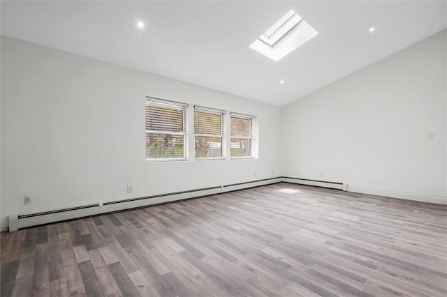 empty room with high vaulted ceiling, light hardwood / wood-style floors, a baseboard radiator, and a skylight