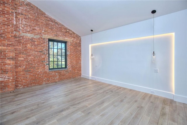 41 Richmondville Ave Unit 306, Call Listing Agent, CT 06880 - empty room featuring lofted ceiling, wood finished floors, brick wall, and baseboards