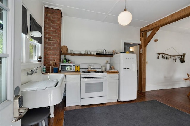 kitchen featuring dark hardwood / wood-style flooring, white cabinets, hanging light fixtures, and white appliances