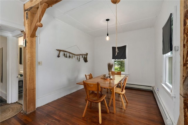 dining space with dark hardwood / wood-style floors, crown molding, and a baseboard heating unit