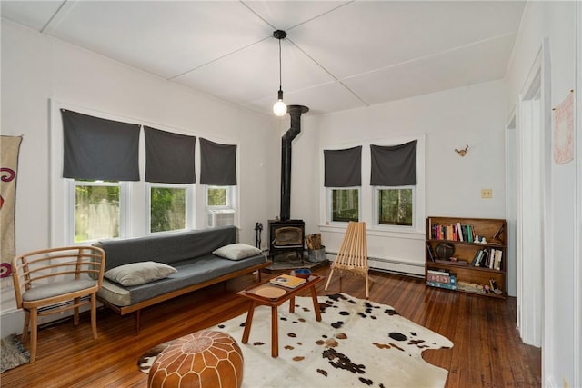 living room featuring a wood stove, a baseboard radiator, and hardwood / wood-style flooring