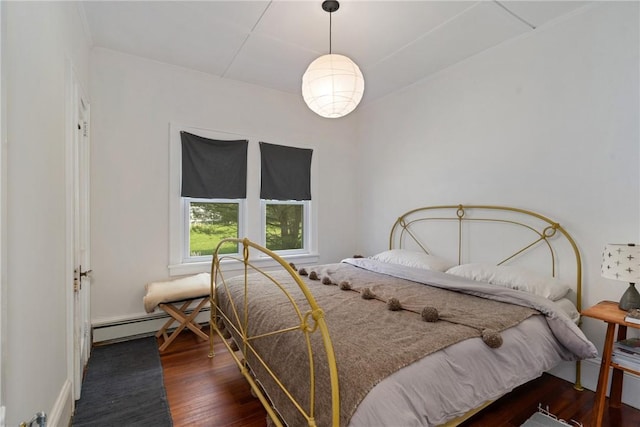 bedroom with baseboard heating and dark wood-type flooring