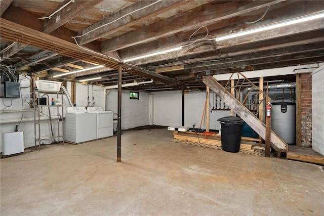 basement featuring washer and dryer, electric panel, and water heater