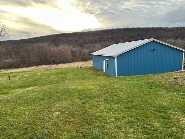 yard at dusk featuring an outbuilding