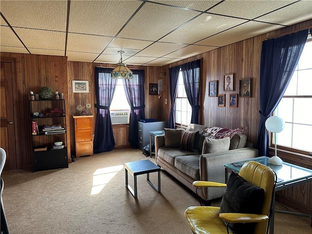 carpeted living room featuring a wealth of natural light, cooling unit, and wood walls