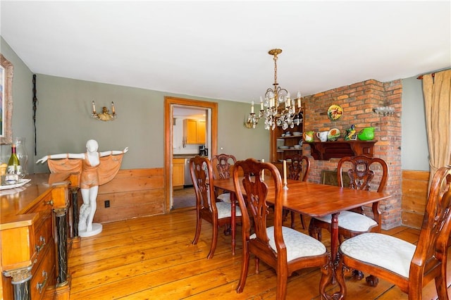 dining room with light wood-type flooring and an inviting chandelier