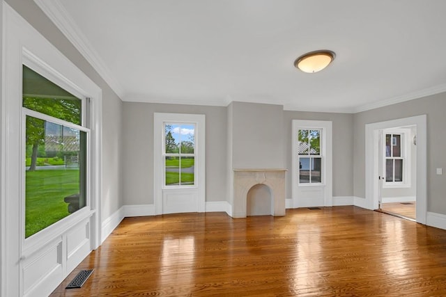 unfurnished living room featuring ornamental molding and hardwood / wood-style flooring