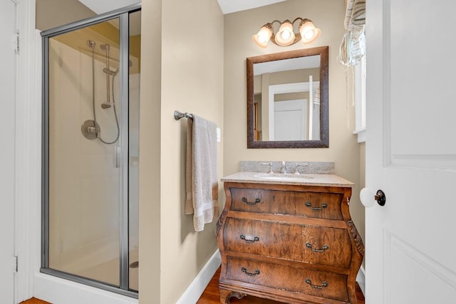 bathroom with hardwood / wood-style floors, vanity, and a shower with shower door