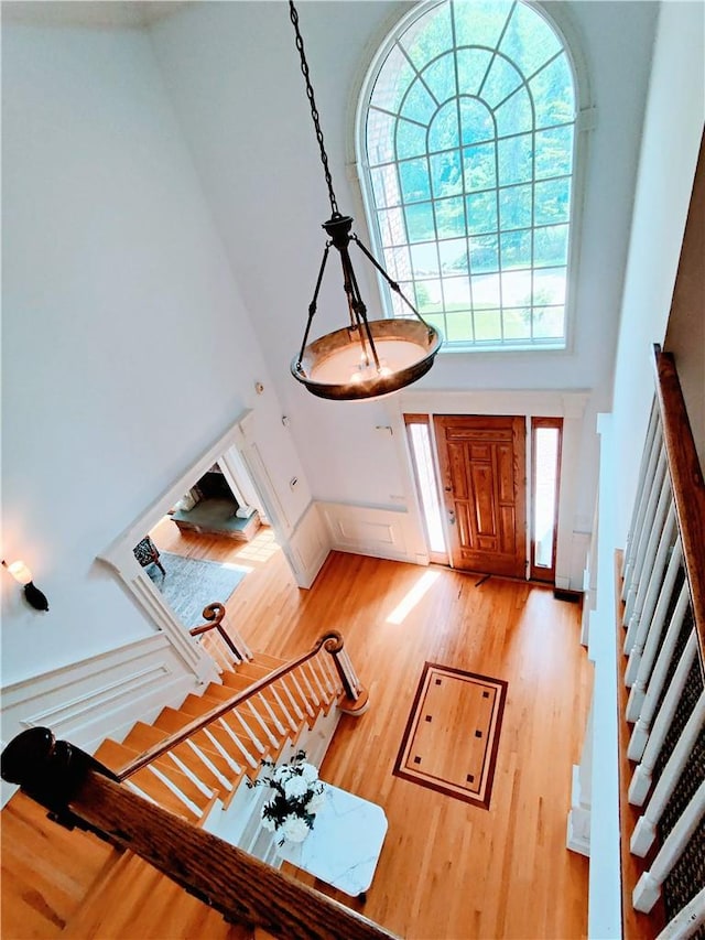 foyer entrance with wood-type flooring and a high ceiling