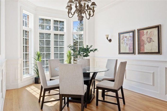 1790 Grandview Dr, Orient, NY 11957 - dining room with a chandelier, crown molding, a decorative wall, light wood finished floors, and wainscoting