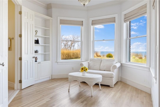 sitting room with light hardwood / wood-style flooring and crown molding