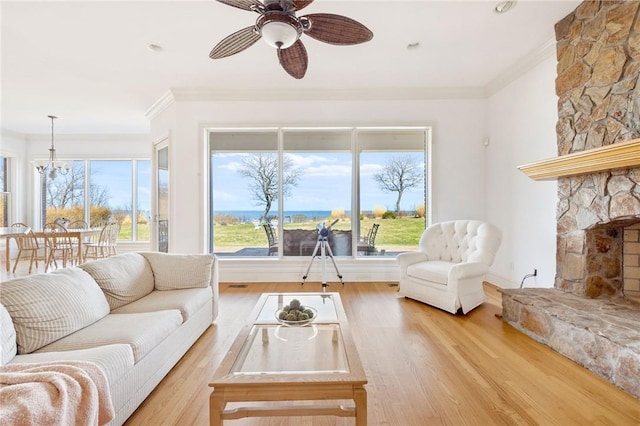 1790 Grandview Dr, Orient, NY 11957 - living room with crown molding, ceiling fan, wood finished floors, a fireplace, and a chandelier