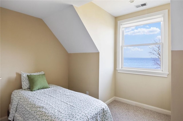 carpeted bedroom with a water view and vaulted ceiling