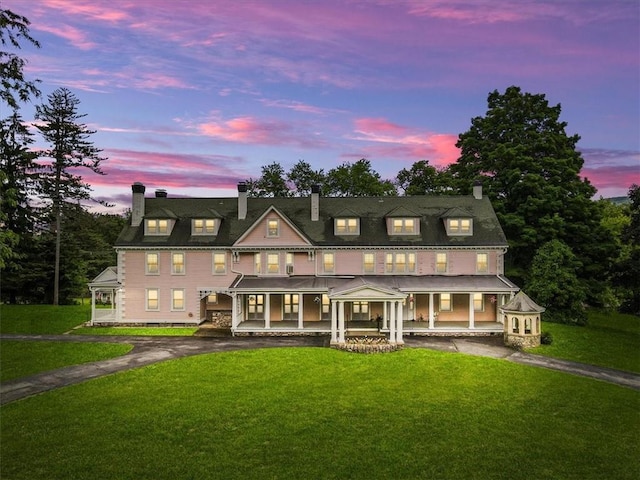 view of front of property featuring a porch and a lawn