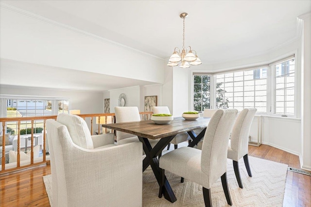 dining room featuring a chandelier, light wood finished floors, and ornamental molding