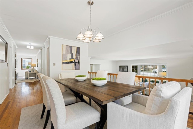 dining area with a notable chandelier, hardwood / wood-style flooring, and crown molding