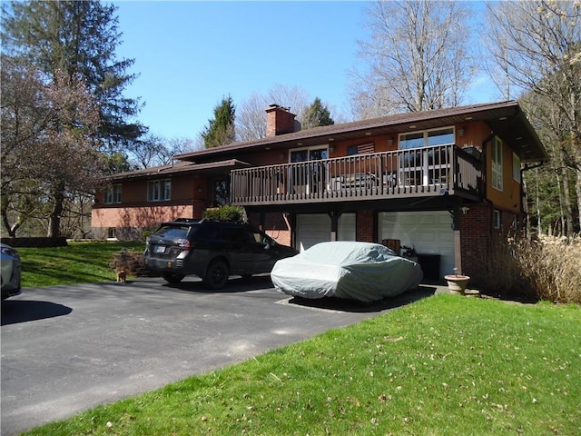 view of front of property featuring a deck, a front yard, and a garage