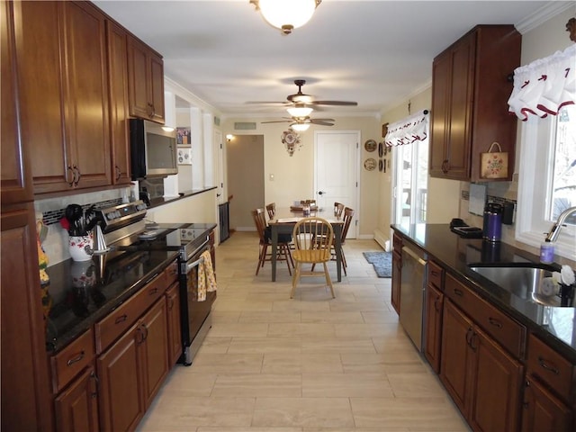 kitchen with ceiling fan, sink, stainless steel appliances, and crown molding