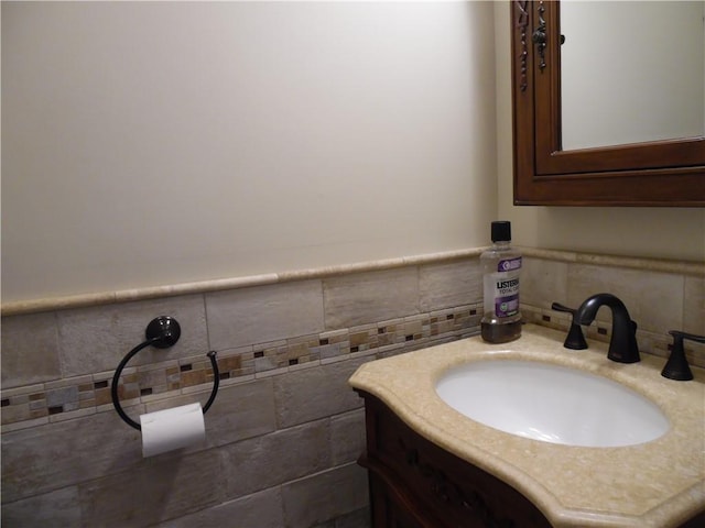 bathroom featuring vanity and tile walls