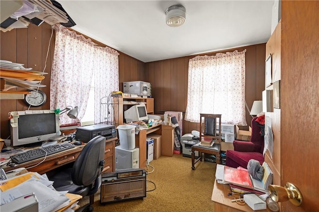 office area with wood walls and light colored carpet